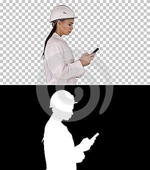 Engineer using mobile phone texting while walking, Alpha Channel