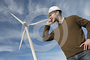 Engineer Using Mobile Phone At Wind Farm