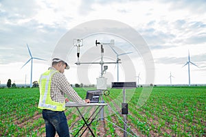 Engineer using tablet computer collect data with meteorological instrument to measure the wind speed, temperature and humidity and photo