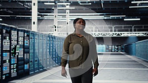 Engineer walking in data center, checking hardware for system stability