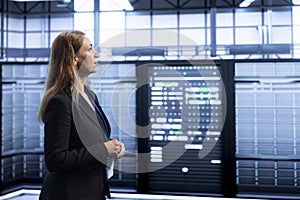 Engineer walking between server rows in data center, doing inspection