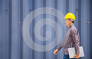 Engineer walking in shipping container yard, Dock foreman worker controlling work proses in the port photo