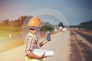 Engineer holding blueprint in construction site