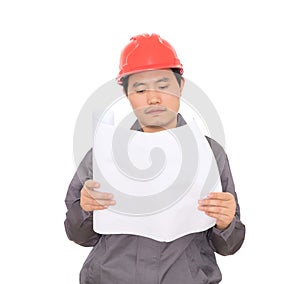 An engineer wearing a hard hat is looking at the drawings