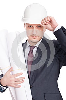 Engineer wearing white hardhat with blueprints