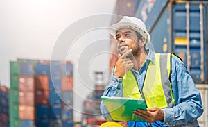 Engineer wears PPE checking container storage with cargo container background at sunset. Logistics global import or export