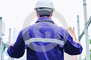 Engineer with white safety helmet holding project plan at construction outdoor site background