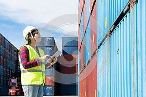 Engineer woman or Foreman manager in container depot working with digital tablet for control and checking industrial container