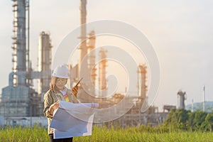 Engineer woman holding blueprint with radio for workers security control at power plant energy