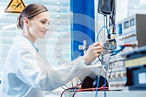 Engineer woman measuring electronic product on test bench
