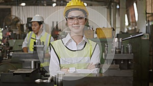 Engineer woman worker wear safety goggles control lathe machine industrial manufacturing factory crossed