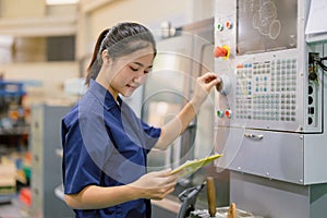 Engineer women control operate CNC industrial machine in metal production workshop. Asian young female industry worker