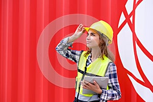 Engineer women wear yellow helmets and reflection shirts working on tablet computers to check inventory details of containers box