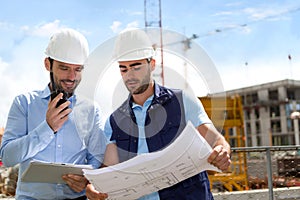 Engineer and worker checking plan on construction site