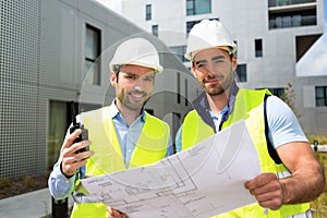 Engineer and worker checking plan on construction site