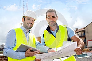 Engineer and worker checking plan on construction site