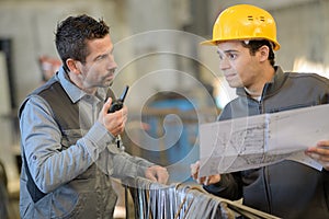 Engineer and worker checking plan on construction site