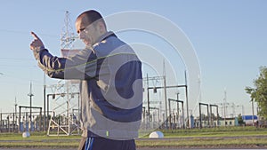 Engineer and Worker at Electrical Substation. Worker with blueprints and clipboard in meeting at electrical substation.