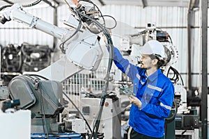 Engineer worker fix service replace broken part of automatic industry robotic welding arm. technician staff repair maintenance