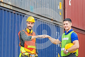 Engineer and worker making a fist bump with blurred containers cargo background, Business success and teamwork concept