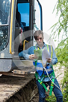 Engineer or Worker Reading manual or work order before driving excavator on construction building site