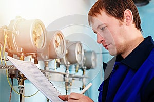 Engineer, worker registers readings of sensors and pressure gauges. Control of water supply and heating system