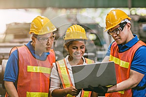 Engineer worker woman with male team working together in factory looking at Laptop computer happy smile