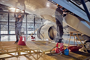 Engineer working on aircraft wing in aircraft maintenance factory