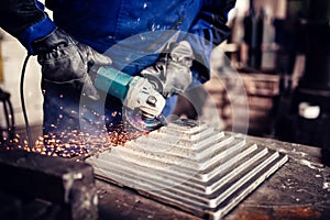 Engineer working on cutting a metal and steel bar with angle grinder, metallurgic factory details