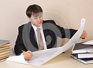 Engineer working with drawing at table in the office