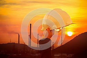 Engineer working with in front oil refinery or woman hand holding helmet on factory