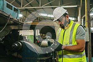 Engineer working at industrial machinery in factory.