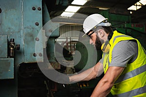 Engineer working at industrial machinery in factory.