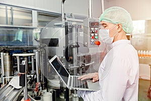 Engineer working with laptop in food factory machine production inspector with hygiene clothes