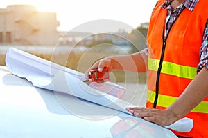 Engineer working on outdoor checking plan on building site