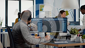 Engineer working on PC, screen showing CAD software with 3D components