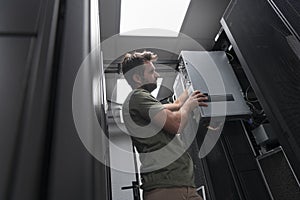 IT engineer working In the server room or data center The technician puts in a rack a new server of corporate business