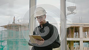 Engineer working on tablet in hand on construction site.