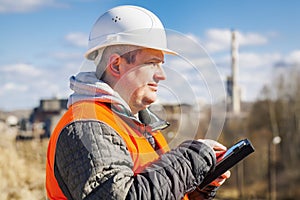 Engineer working with tablet PC near factory