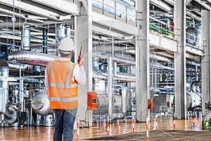 Engineer working in a thermal power plant with talking on radio