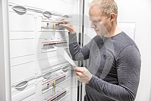 IT engineer works in large fuse cabinet