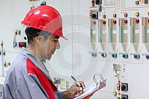 Engineer Writing on Clipboard in Chemical Plant Control Room