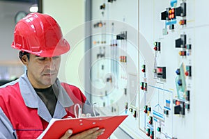 Engineer Writing on Clipboard in Power Plant Control Room