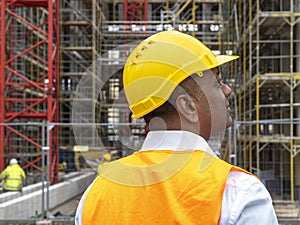 Engineer in yellow hard hat, back turned pose