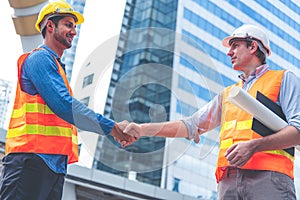 Engineer in Yellow helmet and best greeting with warm handshake manager visiting site. Modern construction and engineering concept