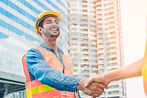 Engineer in Yellow helmet and best greeting with warm handshake manager visiting site. Modern construction and engineering concept