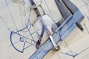 Engineering blueprint with glasses and gauge photo