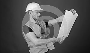 Engineering concept. Engineer, architect, labourer, builder on strict face holds old blueprint in hands. Man, handyman