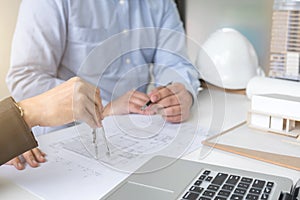 Engineering or Creative architect in construction project, Engineers hands working with compasses on construction blueprint build