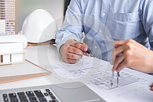 Engineering or Creative architect in construction project, Engineers hands working with compasses on construction blueprint build